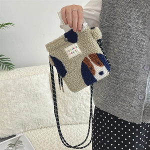 Detail of plush lamb wool crossbody bag with cartoon dog patch and woven strap