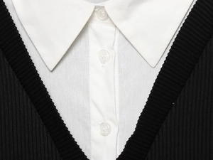 Detalle de cuello de popelina blanca y botones en vestido corto de punto negro