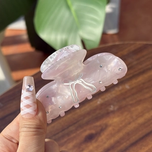 Close-up of a pink marble pattern hair claw clip featuring elegant rhinestone inlay details