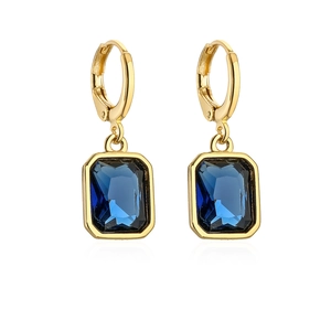 Macro view of 18K gold plated earrings featuring deep blue rectangular zircon pendants