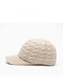 Detailed side view of beige knitted baseball cap featuring thick textured cross-weave pattern