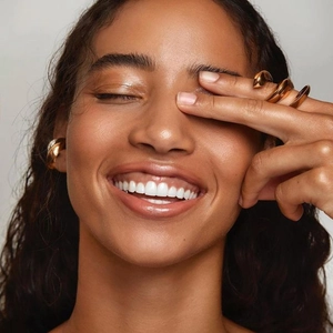 Close-up of model wearing 18k gold plated spring style triple layer ring and earrings set