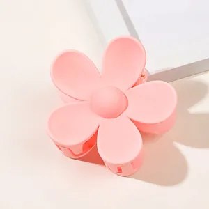 Macro shot of matte pink flower claw clip with smooth petals and durable spring