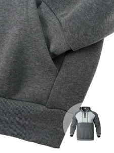 Detail of dark grey hoodie showing ribbed hem and front kangaroo pocket texture
