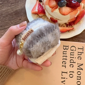 Close-up of plush headphone case with white zipper and decorative pearl pendant