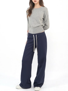 Front view of grey knit crewneck top and dark blue drawstring wide-leg joggers for women