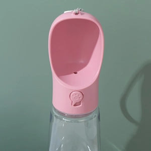 Pink portable dog water bottle with clear body and wrist strap for outdoor travel