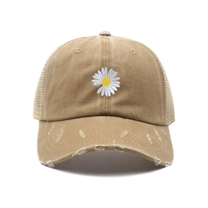 Vintage khaki baseball cap with daisy embroidery and distressed details on white background