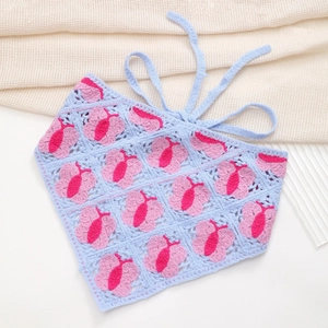 Detail of crochet triangular headscarf featuring blue knit with pink butterfly patterns