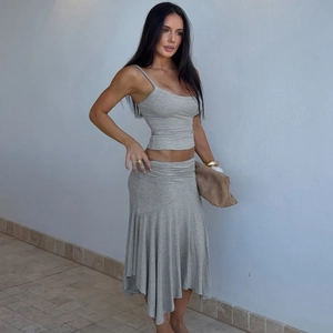 Detail of grey two-piece set featuring a cropped tank top and asymmetrical ruffle skirt