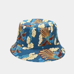 Detail of teal reversible bucket hat featuring golden phoenix and auspicious cloud patterns
