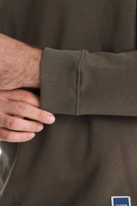 Close-up of olive green ribbed cuffs and cotton knit fabric with fashion woven label