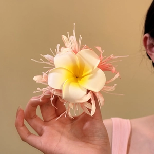 Detailansicht der Frangipani-Haarklammer aus Stoff mit rosa Fransen-Blütenblättern