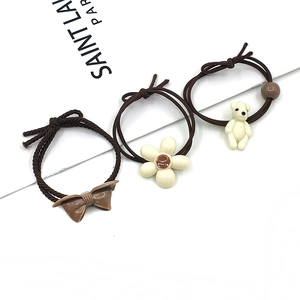 Three-piece brown elastic hair tie set with bow, cream flower, and cute bear charms