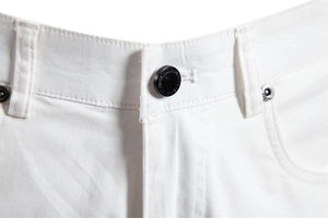 Détail de la taille avec bouton noir mat et double couture sur ce short en coton blanc