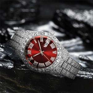 Macro shot of iced-out men's watch featuring red sunburst dial and roman numerals