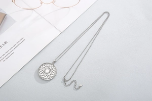 Detail view of round hollow floral necklace with silver chain on an elegant magazine background