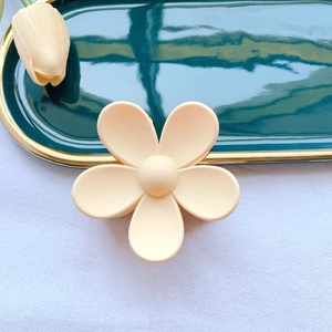 Detailed top view of matte cream flower hair claw clip on vintage tray with tulips