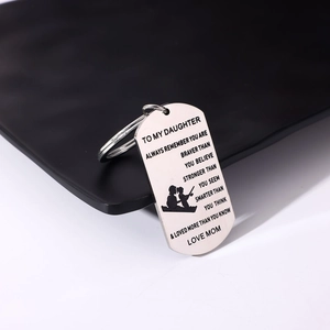 Macro view of stainless steel dog tag keychain with engraved text and fishing silhouette
