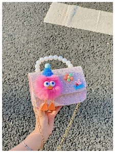 Detail of purple sequin girls bag with pearl handle and plush monster charm