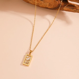 Detailed view of tarot pendant necklace with shell inlay and star patterns on a branch