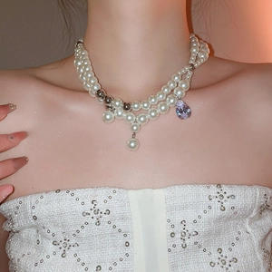 Elegante mehrlagige Perlenkette mit einem tropfenförmigen lila Kristallanhänger