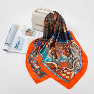 Close-up of a 90cm silk scarf with orange and blue money tree patterns on a beige bag