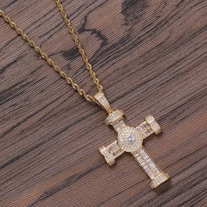 Detailed close-up of a gold cross pendant with square crystals on a twist chain