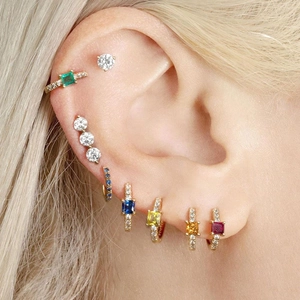 Close-up of model wearing colorful square zircon huggie hoops and stud earrings set