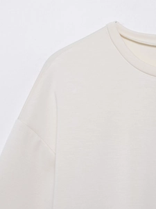Nahaufnahme des Ausschnitts und der Schulternähte eines cremefarbenen Rundhals-T-Shirts