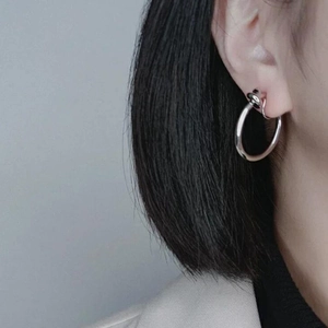 Close-up of a silver metal hoop earring worn by a model for a stylish minimalist look