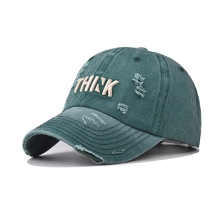 Detail of vintage washed cotton baseball cap with THINK 3D embroidery and distressed holes