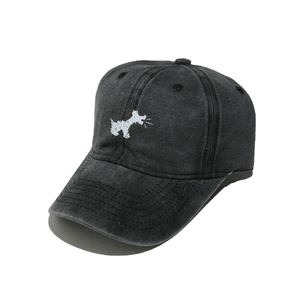 Detailed close-up of a black washed cotton baseball cap featuring a white dog embroidery