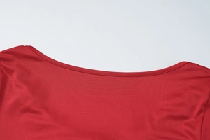 Detailed close-up of the V-neckline and red elastic fabric on the slim-fit long dress