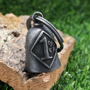 Macro shot of vintage 1% ER guardian bell pendant on textured wood with sharp details