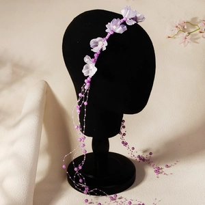 Detail of purple fabric flowers and elegant pearl tassels on a bridal headband