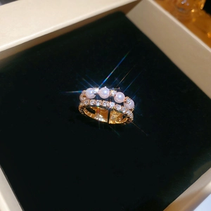 Macro detail of a double-layered gold ring with elegant white pearls and sparkling zircons