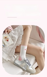 Détail de chaussettes en coton blanc avec broderie de lapin et bordure rose douce