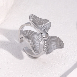Détail d'une bague fleur argentée avec pétales texturés et anneau ouvert ajustable