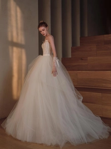 Detailed close-up of ivory wedding dress with lace embroidery and delicate bow straps