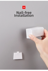 Close-up of the easy adhesive mounting process for white wall-mounted toothbrush holder
