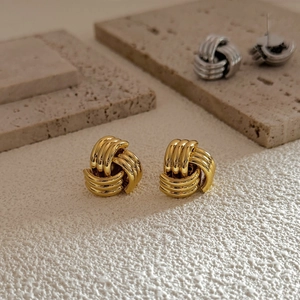 Polished 18K gold plated triangular geometric knot stud earrings for women on marble