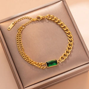 Gold-plated titanium steel bracelet featuring a rectangular green gemstone on a jewelry box