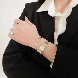 Polished silver irregular cuff bracelet set with matching ring on model wrist