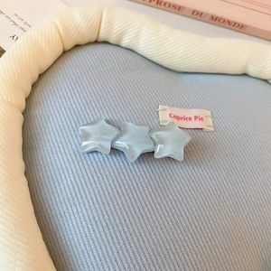 Détail de la pince à cheveux étoile bleue pailletée avec étiquette tissée Caprice Pie