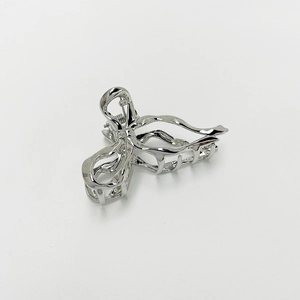 Detail of silver metallic geometric hollow hair claw clip with irregular wave design