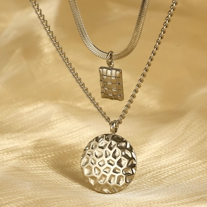 Detail of silver double-layered necklace with textured square and round pendants