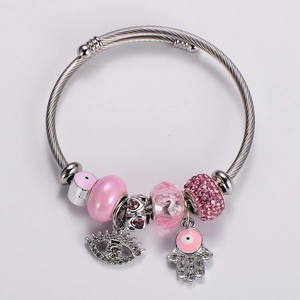 Detail of silver beaded bracelet with pink charms and sparkling evil eye pendant