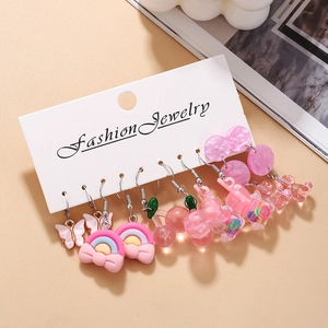 Five pairs of pink resin earrings featuring butterflies and cherry charms on a display card