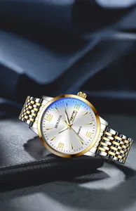 Detail of quartz watch with white dial, gold markers, and bicolor steel strap